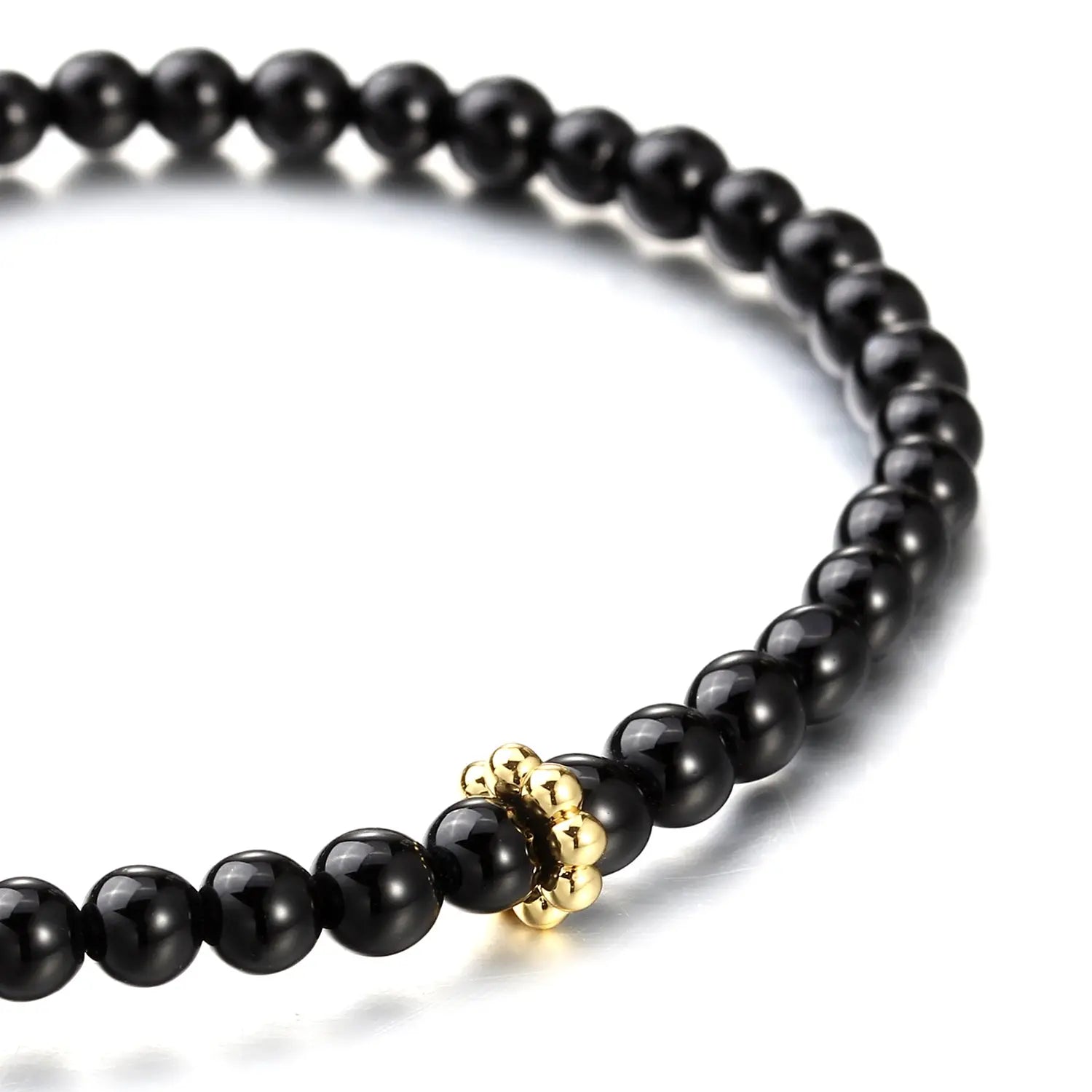 Black beaded bracelet with a gold ring on a white background